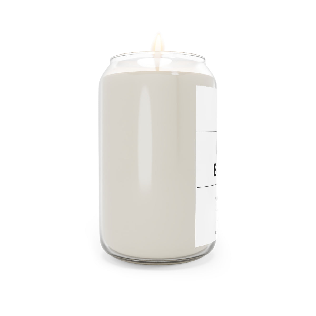 Soy candle in clear jar with flame, off-white wax, label partially visible