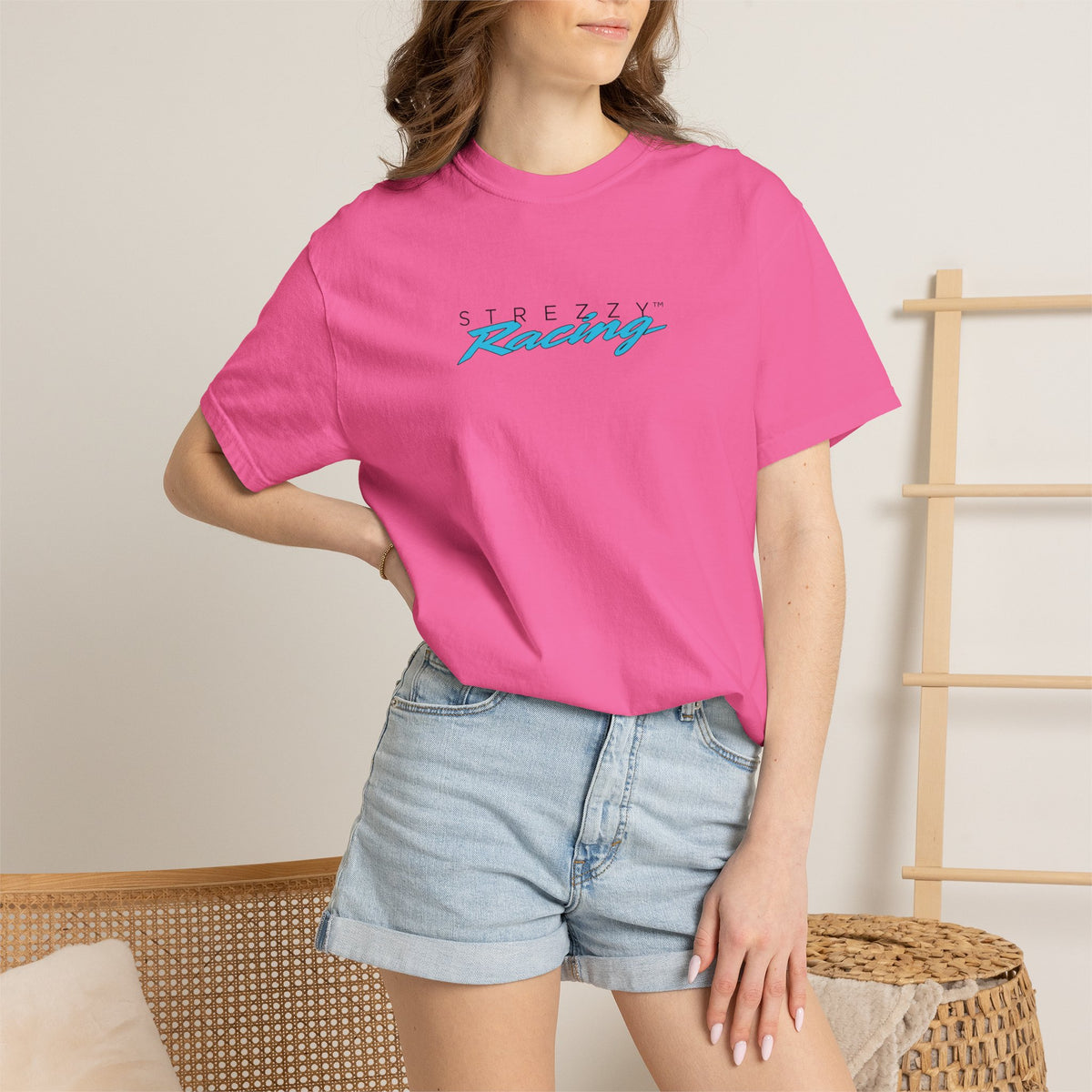 Woman wearing pink short-sleeve crewneck t-shirt with colorful Strezzy Racing logo