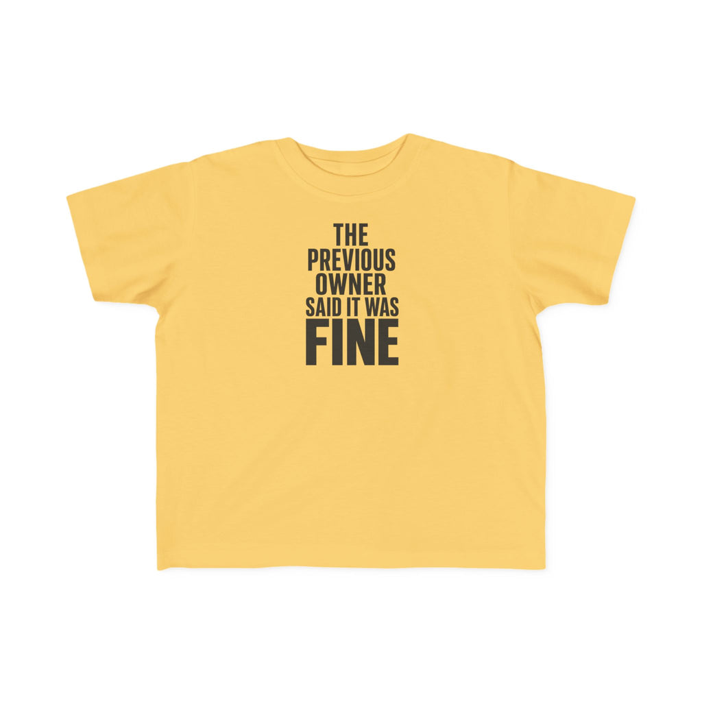Butter yellow toddler graphic t-shirt with centered text "THE PREVIOUS OWNER SAID IT WAS FINE"