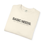 Ivory crewneck T-shirt with 'BASIC NEEDS' graphic logo and tagline