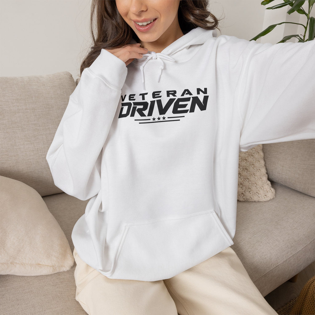 White pullover hoodie with drawstring hood and Veteran Driven graphic, worn by model
