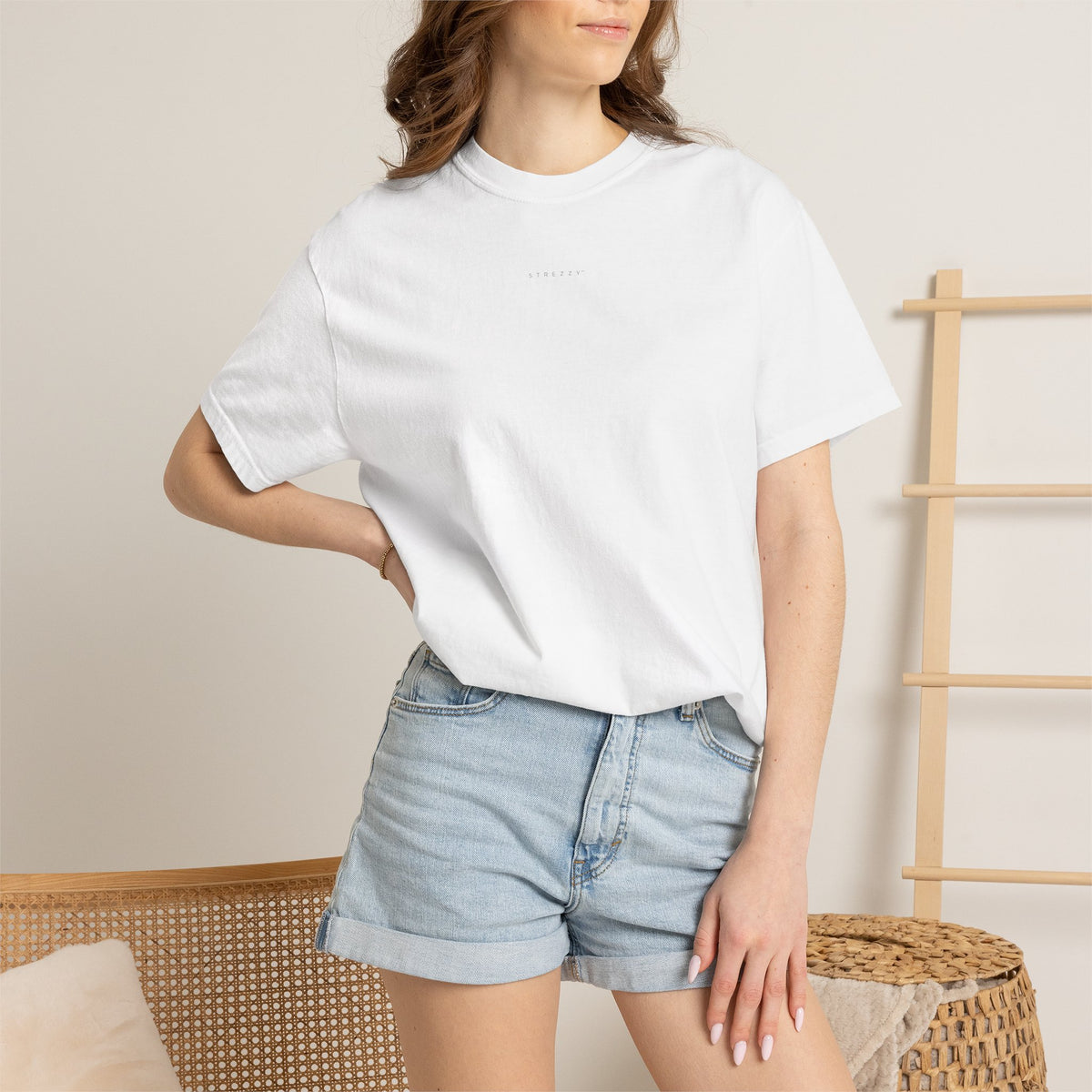 White crew-neck T-shirt worn by model with small chest logo