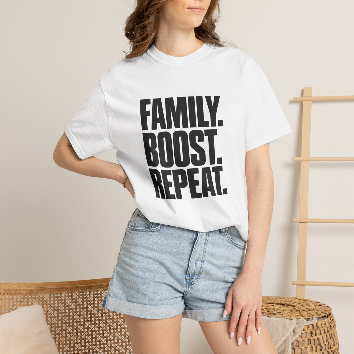 White crew-neck T-shirt with bold black "FAMILY BOOST REPEAT" graphic front