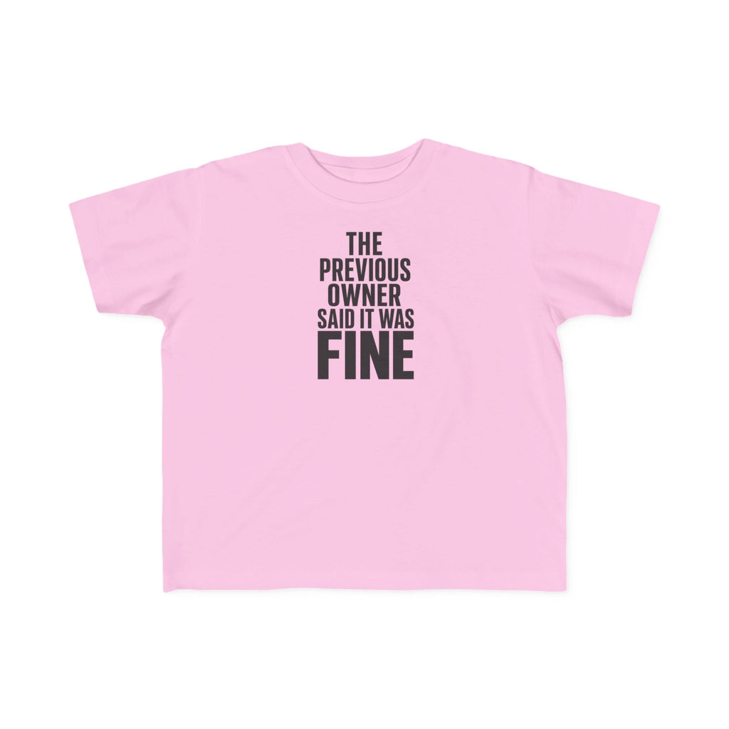 Pink toddler graphic t-shirt with centered "THE PREVIOUS OWNER SAID IT WAS FINE" text