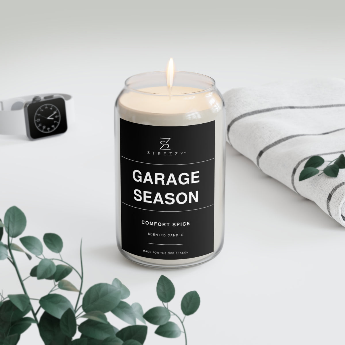 Glass jar candle with black Garage Season label, comfort spice scent, lit wick on top