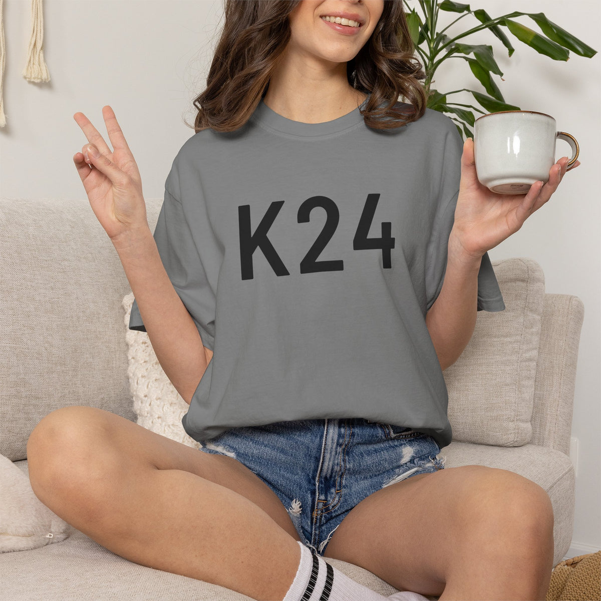 Grey K24 graphic T-shirt on person, crew neck, short sleeves