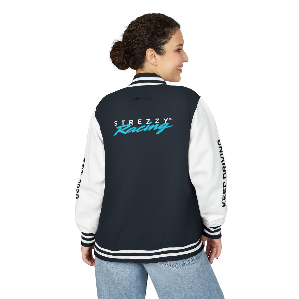 Woman wearing dark varsity racing jacket, back view with white sleeves and racing logo across back