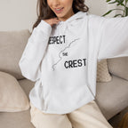 White hoodie on model with drawstring hood, front pouch pocket, and crest graphic