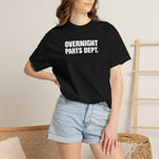 Black crew-neck T-shirt worn by model, featuring "OVERNIGHT PARTS DEPT." logo
