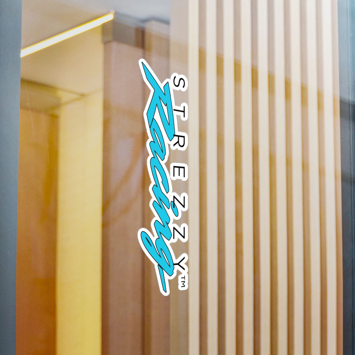 Kiss-cut racing logo sticker on wooden wall panel, teal “Kaching” script