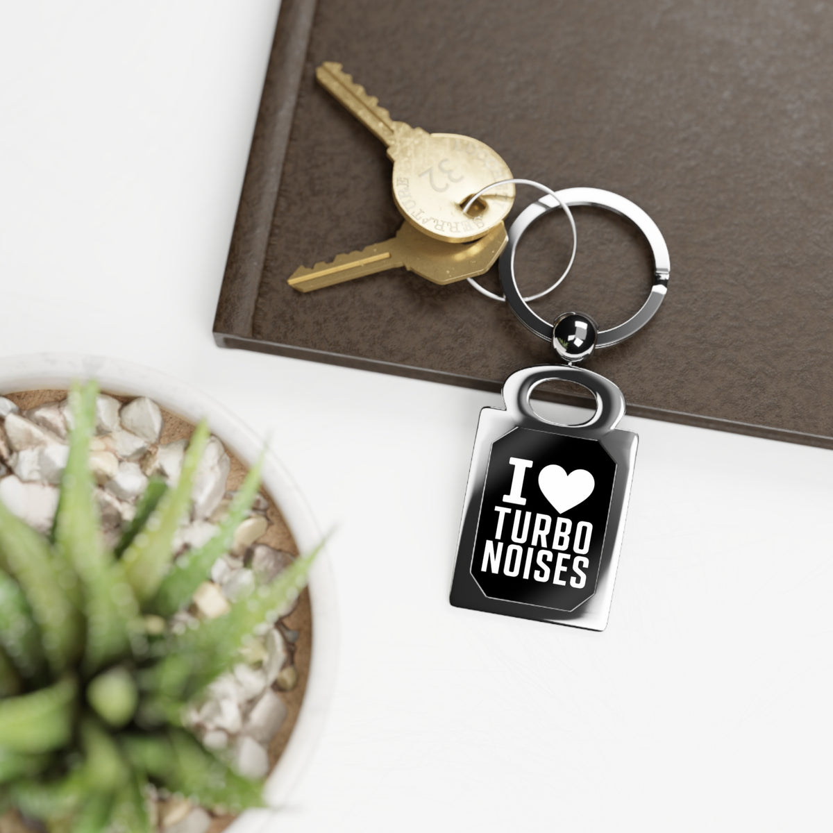 Silver keyring charm with black 'I ♥ TURBO NOISES' tag and attached key