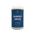 Soy candle in clear glass jar with blue Sunday Drive label and lit wick flame