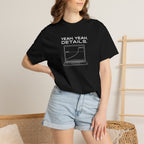 Black crew-neck T-shirt worn by model, front laptop graphic with text visible.