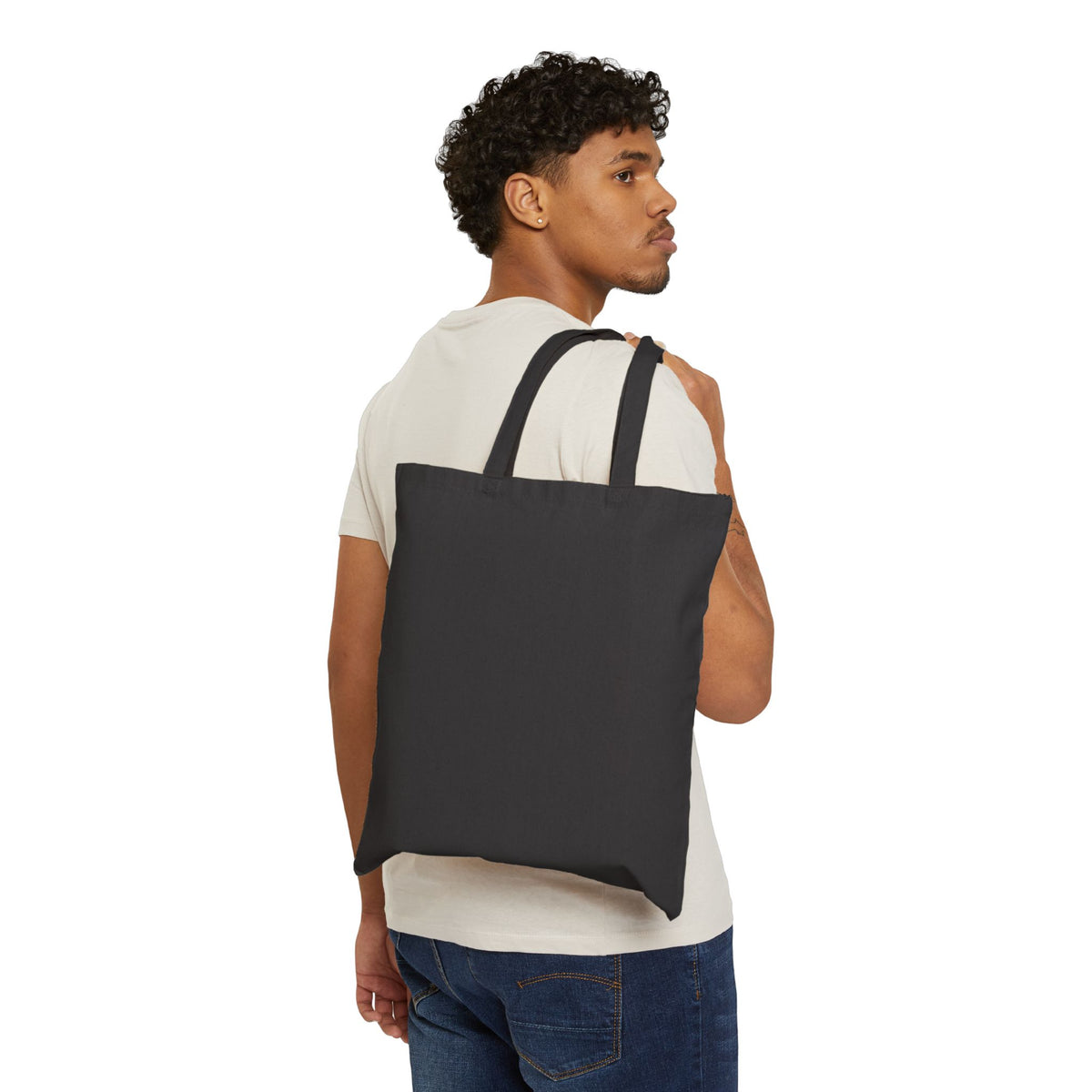 Black canvas tote bag worn on back with two handles, no visible logo.