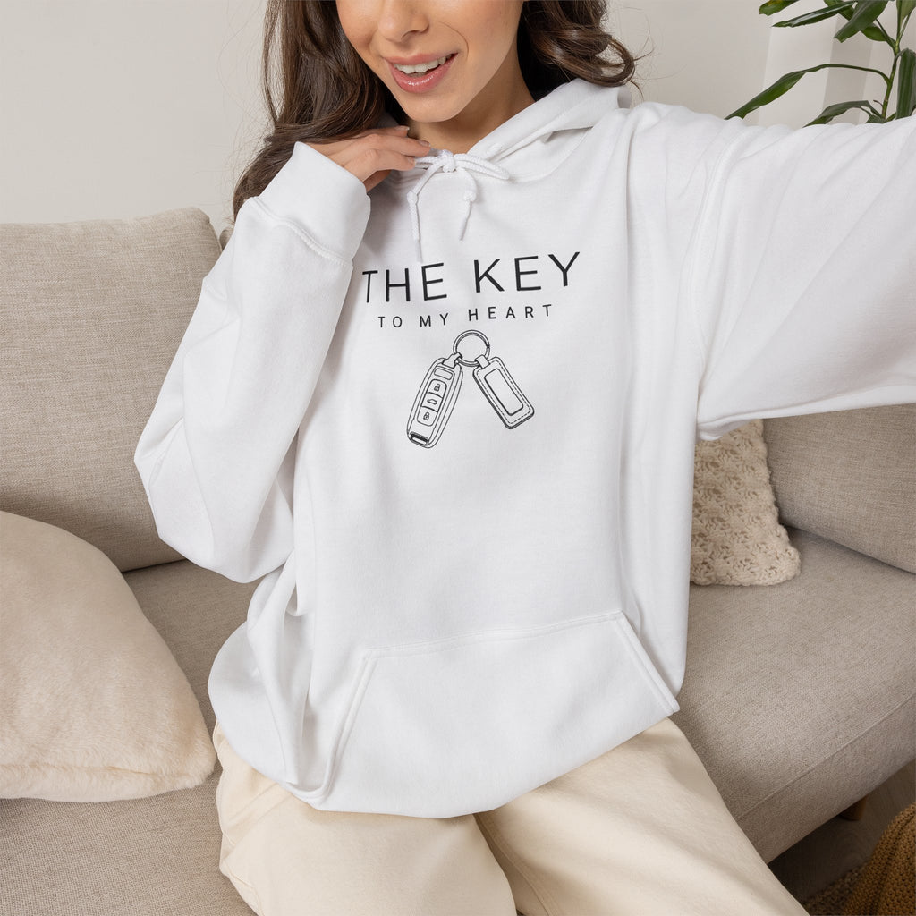 White hoodie worn on model with front logo text and key graphic, front pocket visible
