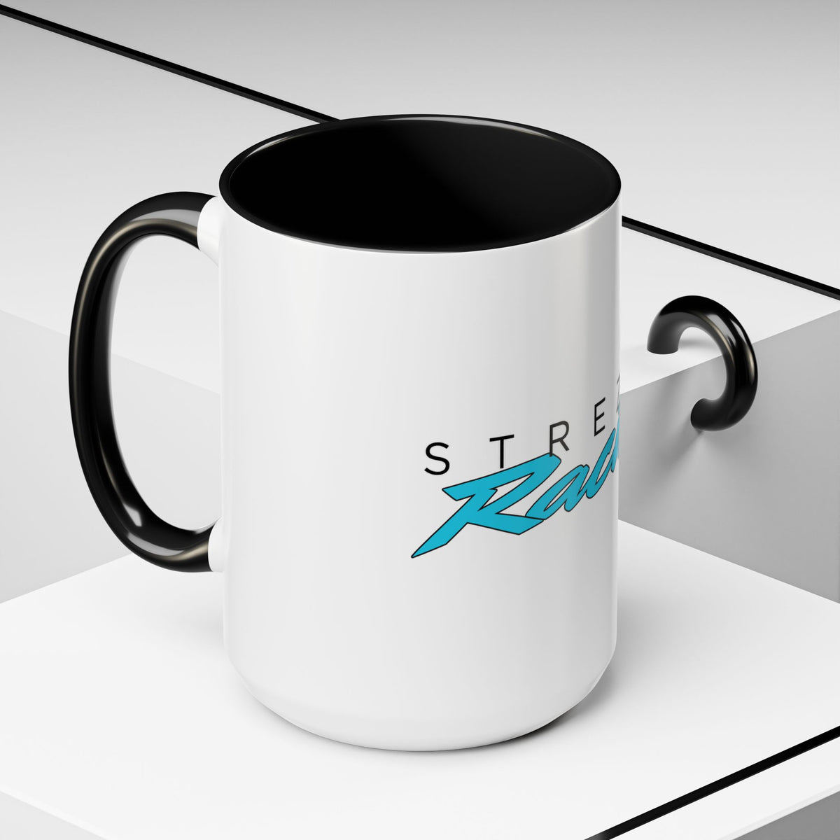 White mug with black rim and handle, featuring racing logo graphic on side